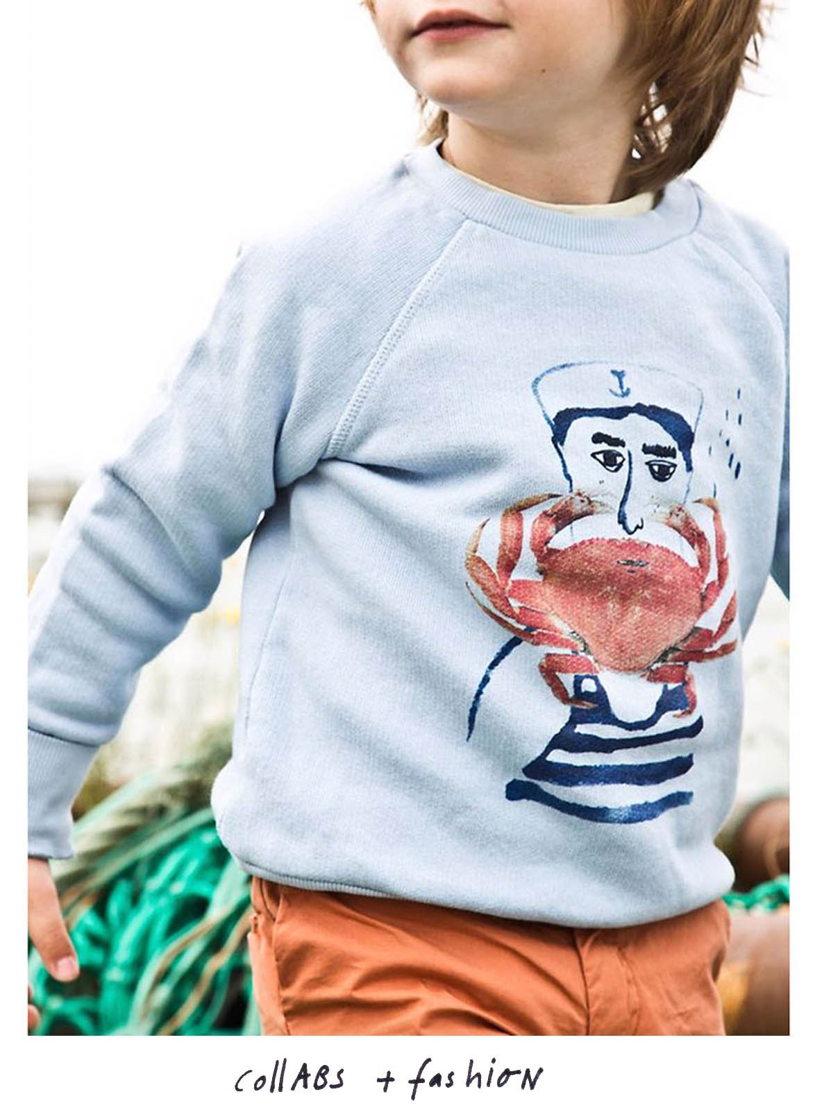 young boy with seater and artwork